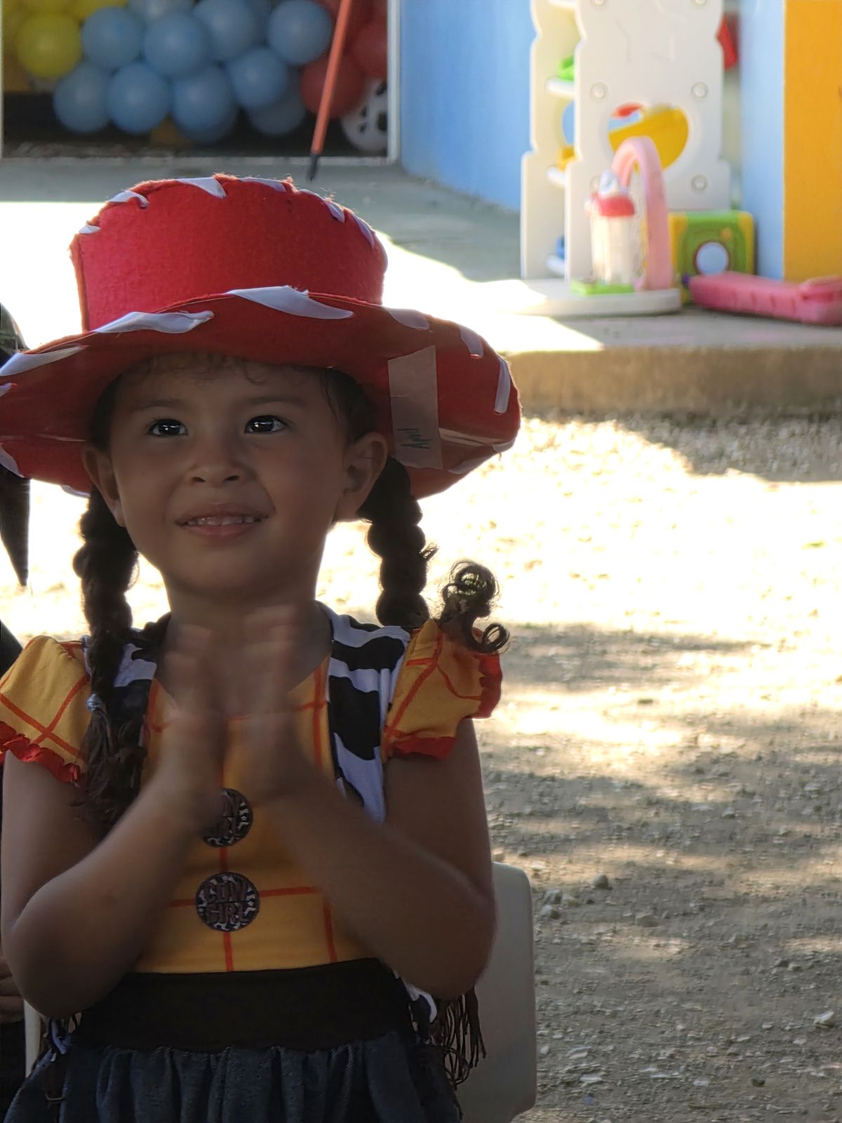 Niña sonriente con disfraz de vaquerita