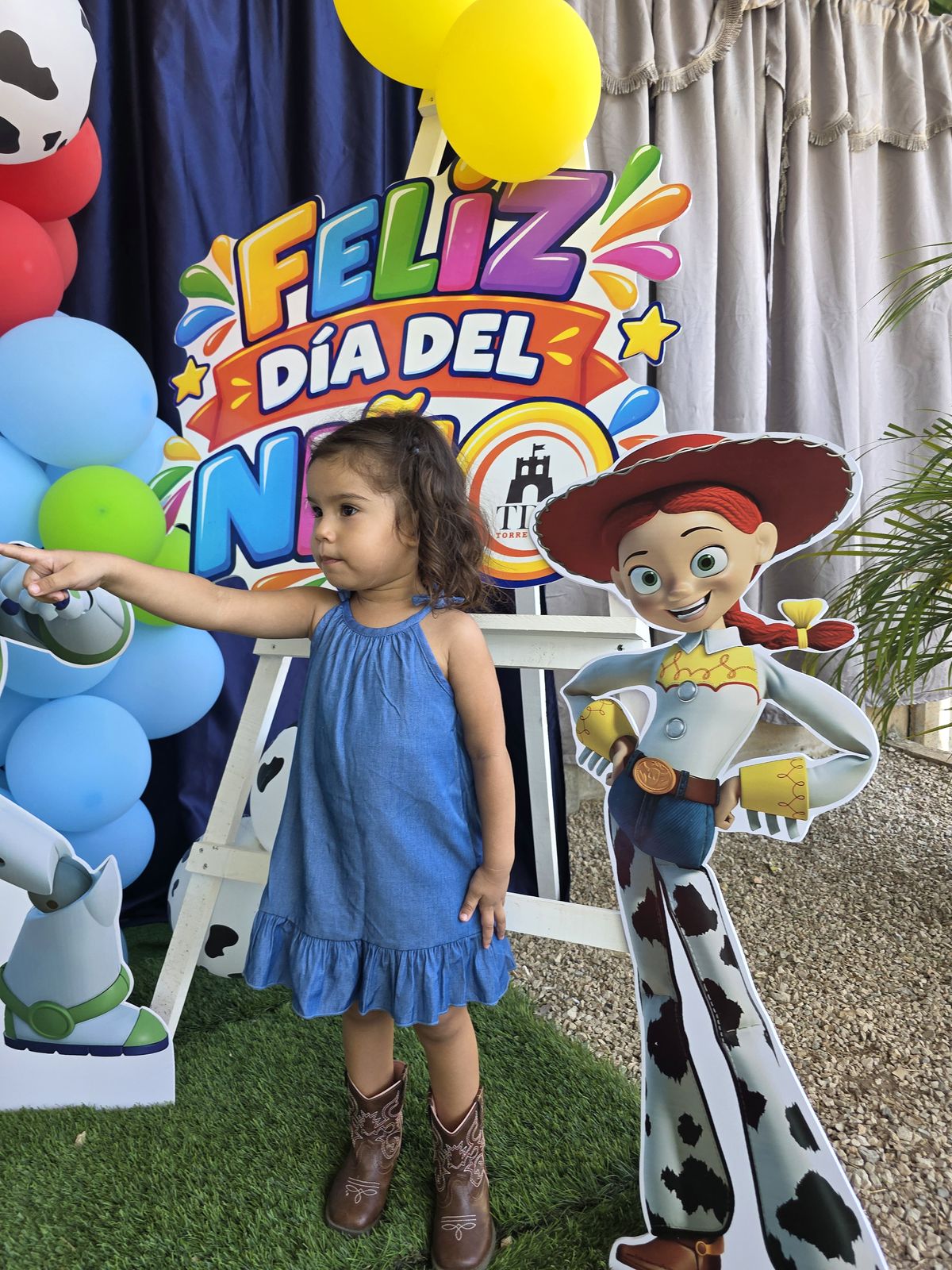 Niña sonriente junto a la decoración del evento