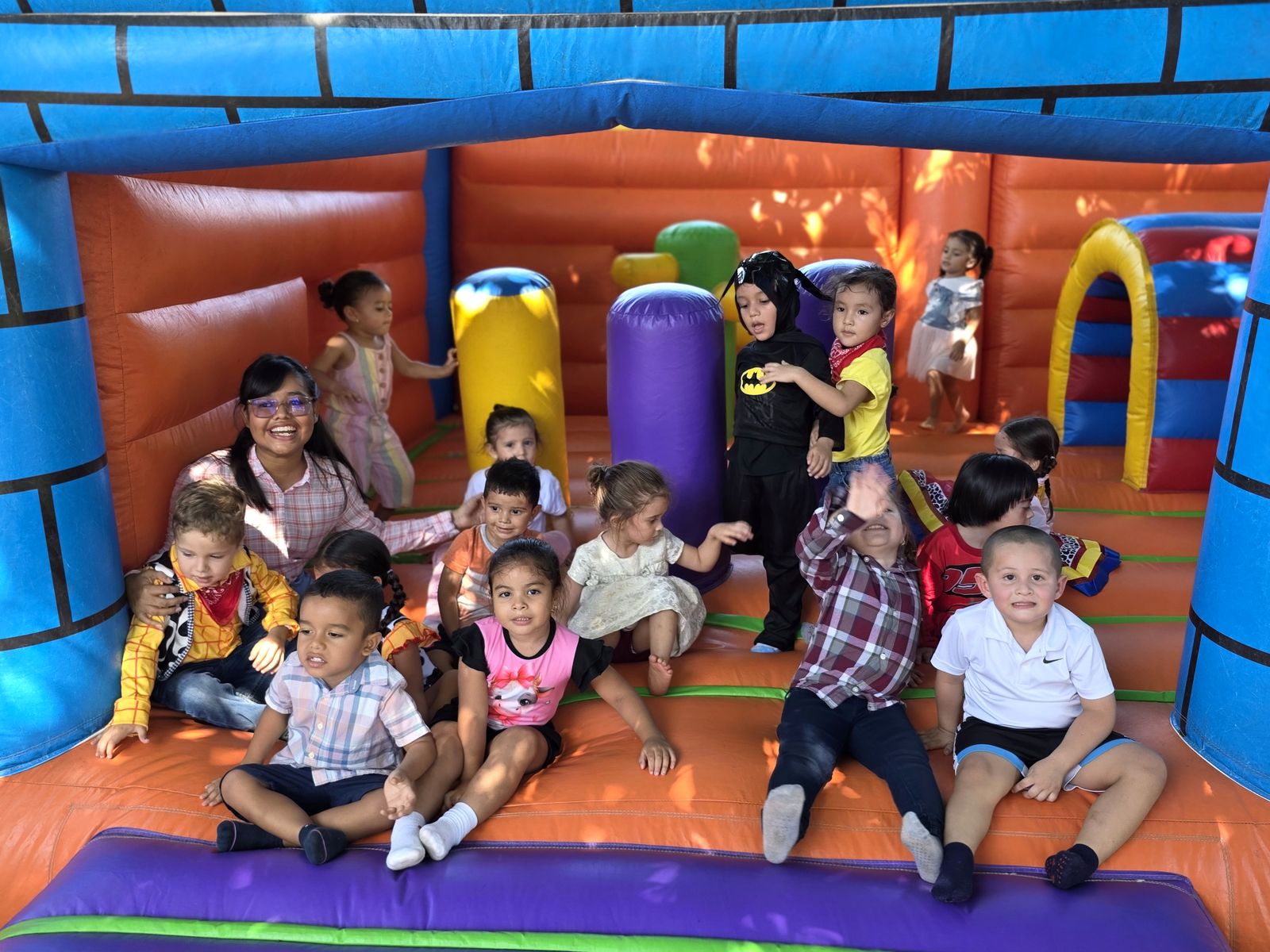 Niños y niñas reunidos y sonriendo en el inflable