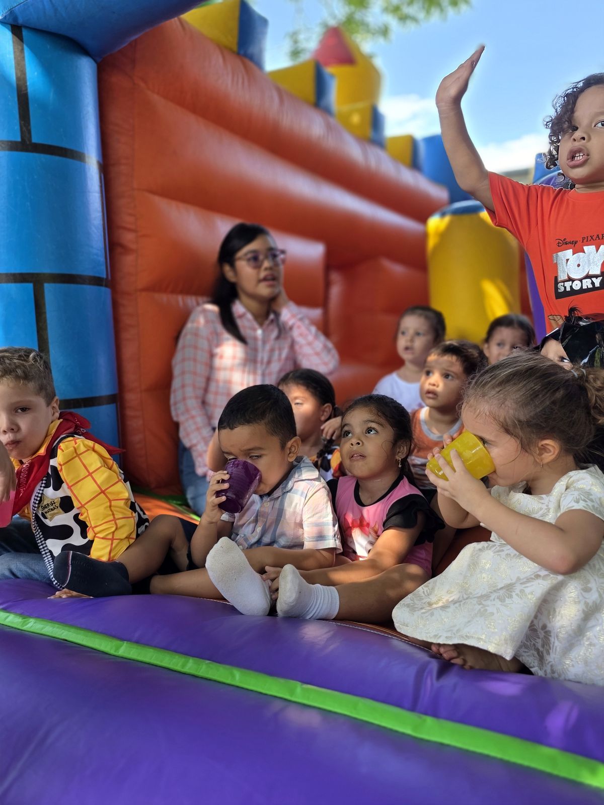 Niños compartiendo una actividad acompañados por adultas