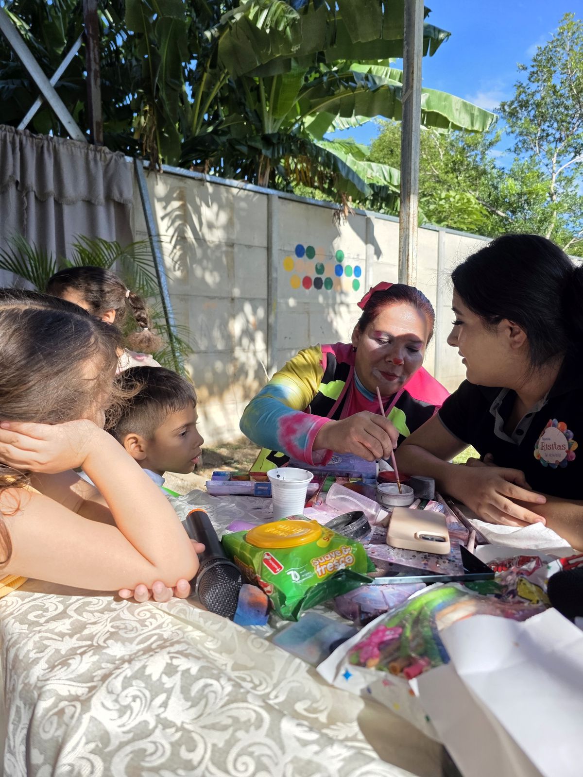 Maestra realizando pintura facial durante la celebración